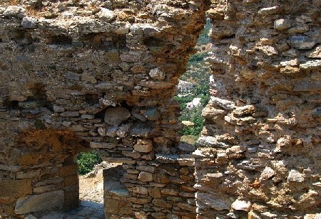 W szczelinach murów można dostrzec okoliczne chatki 