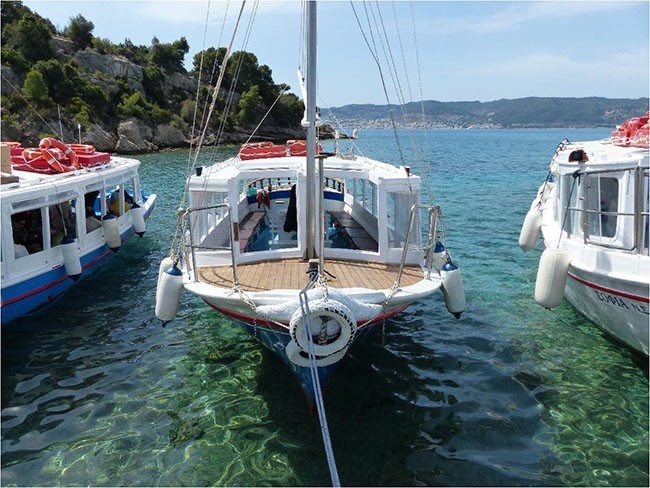 Kosta: statki pływające na wyspę Spetses, którą widać gdzieś tam z tyłu