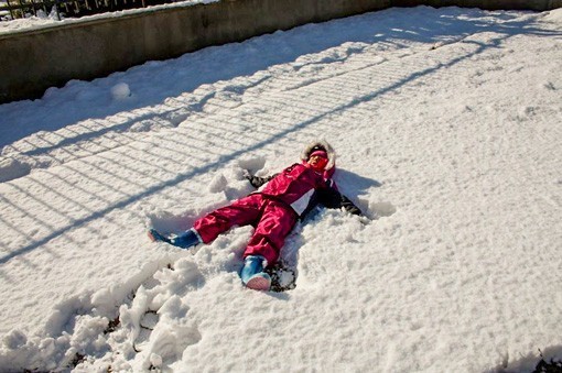 Dziecko robiące aniołka na śniegu